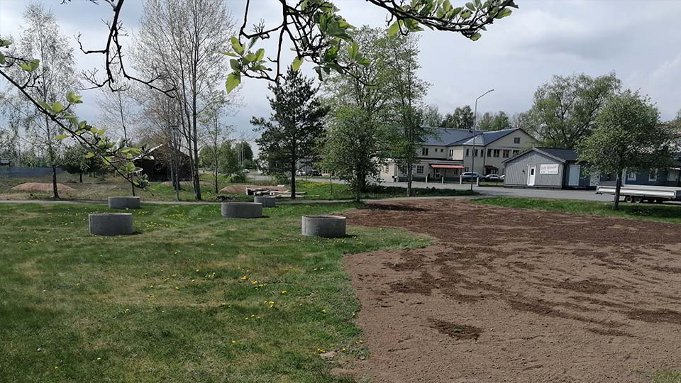 Gräsmatta och grus med runda betongrör, ska bli en pollineringspark.