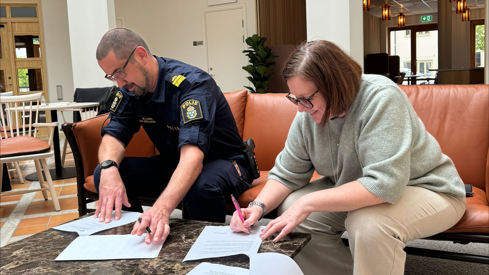 Lokalpolisområdeschef Mathias Ljung och kommunstyrelsens ordförande Beata Allen signerar dokument. Foto.