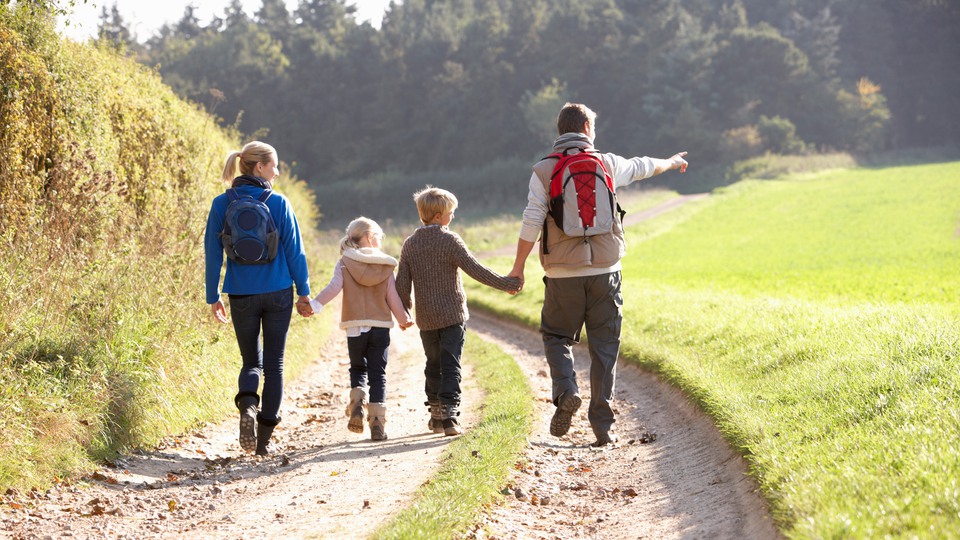 Familj som går på en skog. Foto 