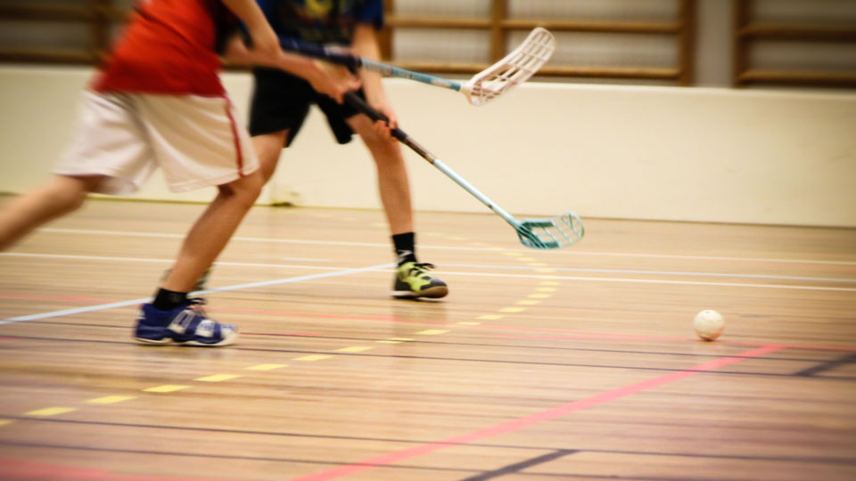 Två barn spelar innebandy. Foto.